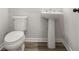 A clean bathroom with a white pedestal sink, a modern toilet, and neutral-toned flooring at 387 Skylar Se Way, Atlanta, GA 30315