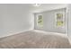 A bright bedroom features neutral carpet, two windows with blinds, and ample natural light at 387 Skylar Se Way, Atlanta, GA 30315