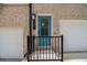 Charming blue front door with brick facade and white garage doors at 387 Skylar Se Way, Atlanta, GA 30315