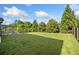Lush backyard featuring a well-manicured lawn, trees, and a covered patio area at 408 Honeybee Ln, Canton, GA 30115