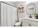 Neutral bathroom with a white vanity, an oval mirror, and a shower with a textured curtain at 408 Honeybee Ln, Canton, GA 30115