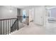 Upstairs hallway with staircase and an open railing; view of a bright bathroom and bedroom at 408 Honeybee Ln, Canton, GA 30115