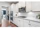 Gourmet kitchen with stainless steel appliances, double ovens, gas cooktop, white cabinets, and granite countertops at 408 Honeybee Ln, Canton, GA 30115