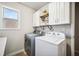 Well-lit laundry room featuring modern washer, dryer, and storage shelves at 408 Honeybee Ln, Canton, GA 30115