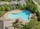 Aerial view of a peanut-shaped neighborhood pool with lounge chairs around the perimeter and several trees surrounding it at 408 Honeybee Ln, Canton, GA 30115