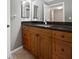 Bathroom vanity with wood cabinets, black countertop, and double mirrors at 53 Monet Nw Ct, Atlanta, GA 30327