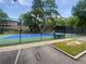 View of the community tennis court with benches, fencing, and manicured green and blue playing surface at 53 Monet Nw Ct, Atlanta, GA 30327
