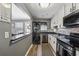 Galley kitchen with stainless steel appliances, granite counters, and washer/dryer at 135 N North River Dr, Atlanta, GA 30350