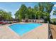 Community pool with lounge chairs and a small pool house surrounded by trees at 135 N North River Dr, Atlanta, GA 30350