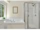 Bathroom featuring a soaking tub with tile surround and a glass-enclosed shower, with a window providing natural light at 229 Brookview Pl, Woodstock, GA 30188