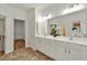 Bathroom featuring double sinks, white cabinetry, tile flooring and access to a large walk-in closet for ample storage at 229 Brookview Pl, Woodstock, GA 30188