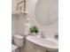 Bathroom features a circular mirror, floating shelf, and a sink with modern fixtures at 229 Brookview Pl, Woodstock, GA 30188