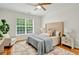 Serene bedroom features a neutral color scheme, hardwood floors, ceiling fan, and a large window providing natural light at 229 Brookview Pl, Woodstock, GA 30188