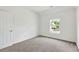 Bedroom features neutral carpet, window with a street view, and white door at 229 Brookview Pl, Woodstock, GA 30188