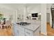 Open-concept kitchen features a center island with cooktop, hardwood floors, and modern lighting fixture above a dining area at 229 Brookview Pl, Woodstock, GA 30188