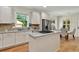 Bright kitchen features white cabinetry, granite countertops, stainless steel appliances and a central island with range at 229 Brookview Pl, Woodstock, GA 30188