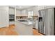 Well-lit kitchen with white cabinets, stainless steel appliances, granite countertops, and a functional center island at 229 Brookview Pl, Woodstock, GA 30188
