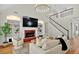 Bright living room with fireplace, large tv, hardwood floors, and staircase at 229 Brookview Pl, Woodstock, GA 30188