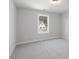 A simple, empty bedroom with neutral carpet and a window showing a house outside at 2723 Byess Ct, Marietta, GA 30064