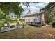 Beautiful backyard featuring a patio with a fire pit and a spacious deck with an umbrella and outdoor furniture at 4261 Vineyard Trl, Snellville, GA 30039