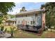 Backyard featuring a patio with fire pit, spacious deck with umbrella and outdoor furniture, and lush greenery at 4261 Vineyard Trl, Snellville, GA 30039