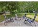 Backyard featuring a cozy brick fire pit surrounded by comfortable seating and mature trees at 4261 Vineyard Trl, Snellville, GA 30039