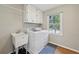 Functional laundry room features a washer, dryer, utility sink, and storage cabinets for convenience at 4261 Vineyard Trl, Snellville, GA 30039