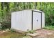 Exterior view of an outdoor white storage shed in a wooded backyard at 4261 Vineyard Trl, Snellville, GA 30039