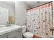 Cozy bathroom featuring a gray vanity, toilet, and shower with a patterned curtain at 4960 Tadmore Ln, Lithonia, GA 30038