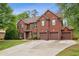 Impressive brick home with a three-car garage and well-manicured lawn in a desirable neighborhood at 4960 Tadmore Ln, Lithonia, GA 30038