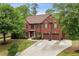 A stately brick home with a well-manicured lawn, three-car garage and charming front entrance at 4960 Tadmore Ln, Lithonia, GA 30038