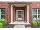 Close-up of a well-kept front porch with brick columns, neat landscaping, and an ADT security sign at 4960 Tadmore Ln, Lithonia, GA 30038