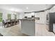 Open-concept kitchen and dining area featuring white cabinets, stainless steel appliances, and tile flooring at 4960 Tadmore Ln, Lithonia, GA 30038