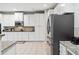Bright kitchen featuring white cabinets, granite countertops, and stainless steel refrigerator at 4960 Tadmore Ln, Lithonia, GA 30038
