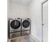 Laundry room with stacked washer and dryer units next to white door at 4960 Tadmore Ln, Lithonia, GA 30038