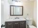 Clean bathroom with a wood vanity, framed mirror, toilet, and neutral paint, offering a functional space at 5320 Taylor Rd, Alpharetta, GA 30022