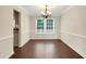 Bright dining area with hardwood floors, classic chandelier, and a window overlooking the backyard at 5320 Taylor Rd, Alpharetta, GA 30022