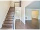 Spacious foyer featuring hardwood floors, stairs with light wood treads, and views into other rooms of the home at 5320 Taylor Rd, Alpharetta, GA 30022
