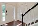 Bright foyer showcasing a stylish front door with sidelights, wood floors, and staircase with a black railing at 5320 Taylor Rd, Alpharetta, GA 30022