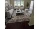 Stylishly staged living room with neutral furniture, patterned rug, and view of the backyard at 5320 Taylor Rd, Alpharetta, GA 30022
