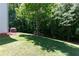 Wide view of a large backyard featuring a grass lawn, trees and the side of a house at 2412 Wingfield Dr, Austell, GA 30106