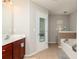 Bright bathroom featuring a soaking tub, tile flooring, and a vanity with dual sinks and dark wood cabinets at 2412 Wingfield Dr, Austell, GA 30106