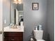 Neutral-toned bathroom featuring a single sink vanity with dark wood cabinets and framed mirror on gray walls at 2412 Wingfield Dr, Austell, GA 30106