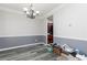 Dining room with gray walls, white crown molding, gray wainscoting and luxury vinyl flooring with a modern light fixture at 2412 Wingfield Dr, Austell, GA 30106