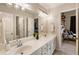 Bright bathroom features a double vanity, a large mirror with modern lights, and a view into the bedroom at 2660 Burnt Hickory Dr, Cumming, GA 30028