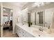 Bright bathroom features a double vanity, a large mirror with modern lights, and an entry to a shower at 2660 Burnt Hickory Dr, Cumming, GA 30028
