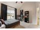 Bright bedroom features a high ceiling, large windows with dark curtains, and a sleek black bookshelf at 2660 Burnt Hickory Dr, Cumming, GA 30028