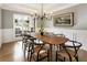 Elegant dining room featuring a modern chandelier, wainscotting, a large window, and hardwood floors with ample light at 2660 Burnt Hickory Dr, Cumming, GA 30028