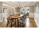 Stylish dining room with hardwood floors, a large window, modern chandelier, and elegant wainscoting for a sophisticated ambiance at 2660 Burnt Hickory Dr, Cumming, GA 30028