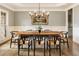Inviting dining room features modern lighting, hardwood floors, wainscotting, a large window, and a decorative painting at 2660 Burnt Hickory Dr, Cumming, GA 30028